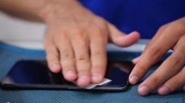 Bakım ve akıllı telefonları tamir etmek. El telefon ekranını temizliyor. Bir sürü sertleştirilmiş cam ekran koruyucu. Mobil ekran koruyucusu. Koruyucu kapak filmi kurulumu
