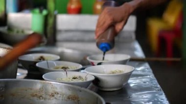 Seçici odak noktası Mie ayam, mi ayam ya da bakmi ayam Endonezya 'da tavuk bakmisi, kelimenin tam anlamıyla tavuk eriştesi, Endonezya' da yaygın olarak kullanılan, dilimlenmiş tavuk eti üzerine baharatlı sarı buğday eriştesidir.,