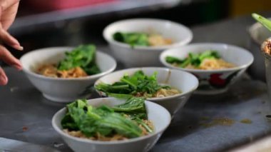 Seçici odak noktası Mie ayam, mi ayam ya da bakmi ayam Endonezya 'da tavuk bakmisi, kelimenin tam anlamıyla tavuk eriştesi, Endonezya' da yaygın olarak kullanılan, dilimlenmiş tavuk eti üzerine baharatlı sarı buğday eriştesidir.,
