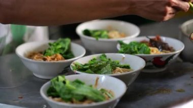 Seçici odak noktası Mie ayam, mi ayam ya da bakmi ayam Endonezya 'da tavuk bakmisi, kelimenin tam anlamıyla tavuk eriştesi, Endonezya' da yaygın olarak kullanılan, dilimlenmiş tavuk eti üzerine baharatlı sarı buğday eriştesidir.,