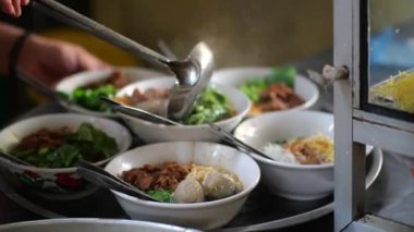 Seçici odak noktası Mie ayam, mi ayam ya da bakmi ayam Endonezya 'da tavuk bakmisi, kelimenin tam anlamıyla tavuk eriştesi, Endonezya' da yaygın olarak kullanılan, dilimlenmiş tavuk eti üzerine baharatlı sarı buğday eriştesidir.,