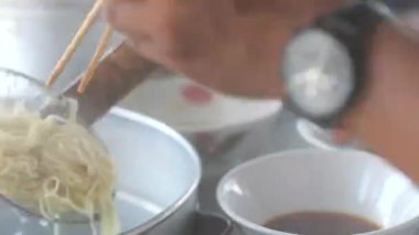 Seçici odak noktası Mie ayam, mi ayam ya da bakmi ayam Endonezya 'da tavuk bakmisi, kelimenin tam anlamıyla tavuk eriştesi, Endonezya' da yaygın olarak kullanılan, dilimlenmiş tavuk eti üzerine baharatlı sarı buğday eriştesidir.,