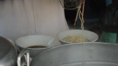 Seçici odak noktası Mie ayam, mi ayam ya da bakmi ayam Endonezya 'da tavuk bakmisi, kelimenin tam anlamıyla tavuk eriştesi, Endonezya' da yaygın olarak kullanılan, dilimlenmiş tavuk eti üzerine baharatlı sarı buğday eriştesidir.,