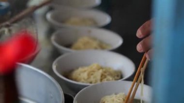 Seçici odak noktası Mie ayam, mi ayam ya da bakmi ayam Endonezya 'da tavuk bakmisi, kelimenin tam anlamıyla tavuk eriştesi, Endonezya' da yaygın olarak kullanılan, dilimlenmiş tavuk eti üzerine baharatlı sarı buğday eriştesidir.,