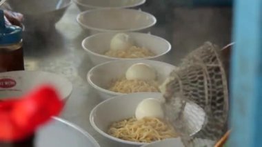 Seçici odak noktası Mie ayam, mi ayam ya da bakmi ayam Endonezya 'da tavuk bakmisi, kelimenin tam anlamıyla tavuk eriştesi, Endonezya' da yaygın olarak kullanılan, dilimlenmiş tavuk eti üzerine baharatlı sarı buğday eriştesidir.,