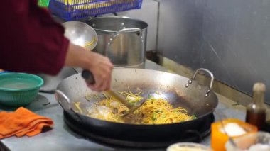 Endonezya usulü kızarmış erişte hazırlanıyor. Mutfakta tavada kızarmış erişte pişiren biri. Etkinlik için geleneksel Endonezya eriştesi. Ev hayatı..