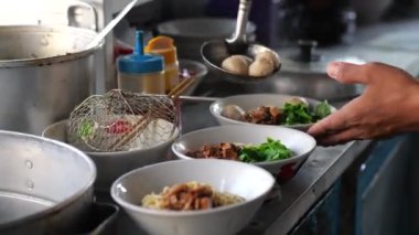 Seçici odak noktası Mie ayam, mi ayam ya da bakmi ayam Endonezya 'da tavuk bakmisi, kelimenin tam anlamıyla tavuk eriştesi, Endonezya' da yaygın olarak kullanılan, dilimlenmiş tavuk eti üzerine baharatlı sarı buğday eriştesidir.,