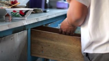 İş adamı elinde para sayar. İş adamı Rupiah 'ı elinde tutar. Adam kağıt para sayıyor. Seçici odak.