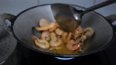 Yağlı tavada kızartılan karideslerin yakın çekimi.