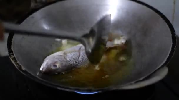 ホットオイルで淡水魚を調理するクローズアップビュー キッチンで熱い調理油と揚げた魚 — ストック動画
