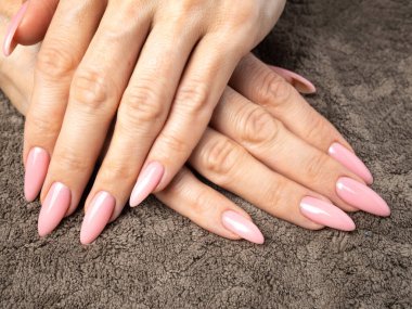 Şık bir çivi genç kadın pembe manikür yapıyor.