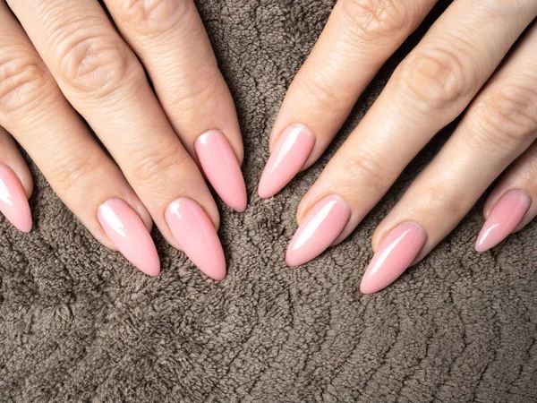 Şık bir çivi genç kadın pembe manikür yapıyor.