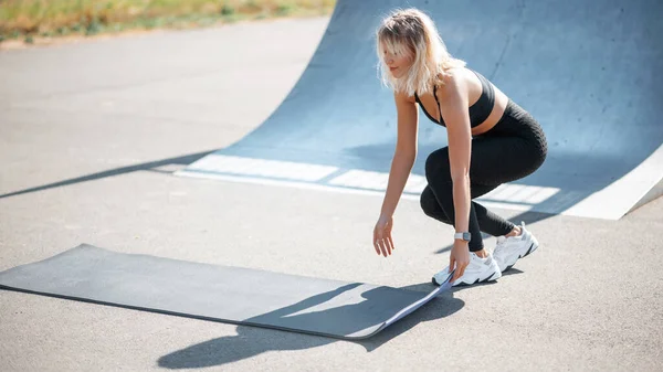 一个女人在夏天准备运动的时候把瑜伽垫放在地上 健康体育生活方式概念 — 图库照片