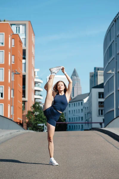 Spor giyimli esnek sarışın kadın esneme egzersizi yapıyor. Spor, aktif yaşam tarzı, sağlıklı yaşam tarzı konsepti