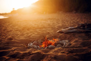 Gün batımında sahilde kamp ateşi. Güzel doğa. Tatilde arkadaş toplanması. Stok fotoğrafı 
