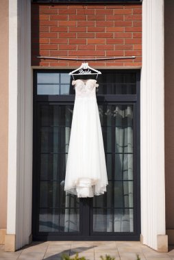 Askıda asılı harika bir gelinlik. Şık kıyafetler gelin için hazırlandı. Parti için modaya uygun kıyafetler.