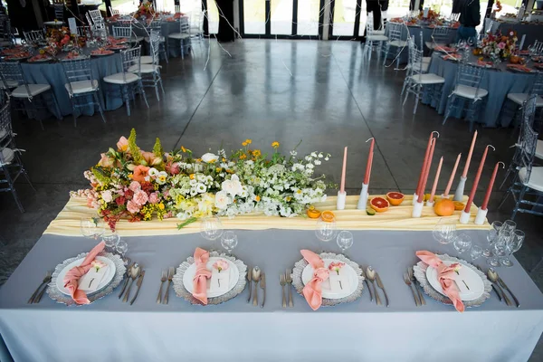 宽敞的现代餐厅大厅 装饰着时髦的节日餐桌 专业服务于餐桌 花的构图作为装饰 结婚的概念 — 图库照片
