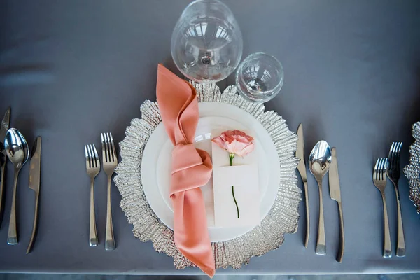 上图是装饰精美的桌子 用灰色的布 白色的盘子 闪亮的餐具和眼镜 粉红餐巾和玫瑰躺在附近 结婚要素 — 图库照片