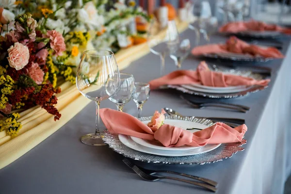 有豪华盘子 餐具和餐巾的时尚节日餐桌 美丽的花束装饰周围 婚礼设计和理念 — 图库照片
