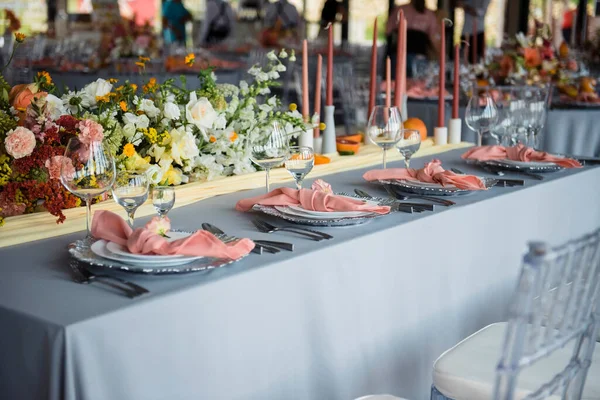 新婚夫妇的婚纱装饰在桌上 在现代餐厅服务的专业人员 装饰用植物元素和蜡烛 — 图库照片