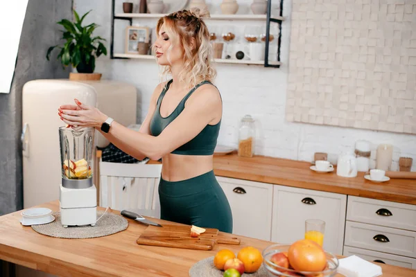 Mulher Jovem Muscular Misturando Frutas Frescas Liquidificador Enquanto Está Cozinha — Fotografia de Stock