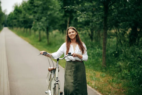 Вид Счастливую Кавказку Идущую Асфальтированной Дороге Зеленом Парке Толкающую Велосипед — стоковое фото