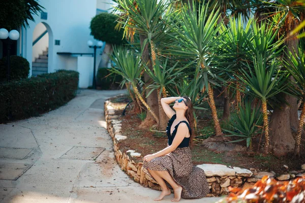 穿着太阳镜和衣服坐在热带度假胜地酒店区的宽松的高加索女人 可爱的黑发女士在豪华度假胜地享受暑假 — 图库照片