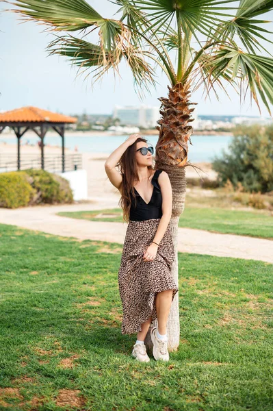 全长肖像美丽的高加索女人穿着时髦的衣服 戴着太阳镜 站在美丽的酒店附近的棕榈树 暑假的乐趣 — 图库照片
