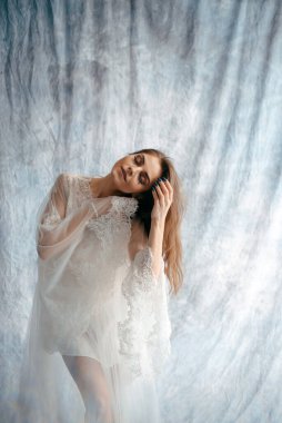 Brunette bride wearing champagne dress and smiles sweetly. Wedding photography. Portrait of a cute bride. Marriage concept 