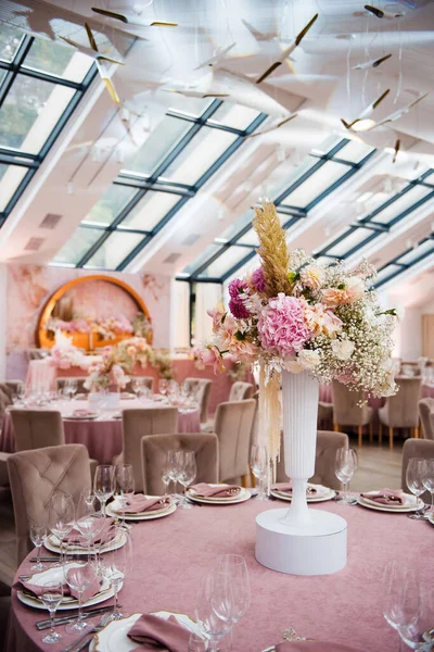 用粉红色桌布装饰婚桌的花的美丽构图 节日餐桌与现代的庆祝大厅完美地结合在一起 — 图库照片