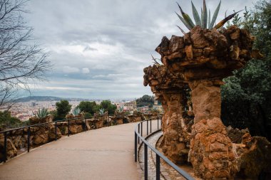 Ünlü Guell Parkı 'ndaki taş oluşumlarının arasındaki patika. İlkbaharda Barselona 'da bitkilerle süslenmiş güzel bir anıt..
