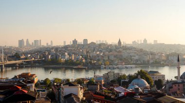 İstanbul 'un mavi gökyüzü üzerindeki Boğaz Köprüsü ile sabah manzarası. Kırmızı çatıları olan geleneksel bir bina. Türk yerel cazibesi ve atmosferi.
