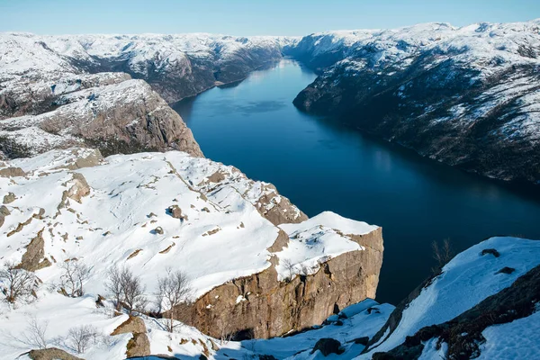 Göl manzarası, nehir, deniz, kayalık kıyılar, karlı tepeler. Minber Rock 'ın en üst görüntüsü, Preikestolen. Lysefjord, Norveç