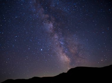 Dağların üzerinde parlak yıldızlarla muhteşem bir akşam göğü. Samanyolu ile güzel bir galaksi. Doğal arkaplan.