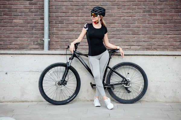 街の通りに黒い自転車で立ってスポーツ服 ヘルメットや眼鏡で運動女性の完全な長さの肖像画 サイクリング レクリエーションの概念 — ストック写真
