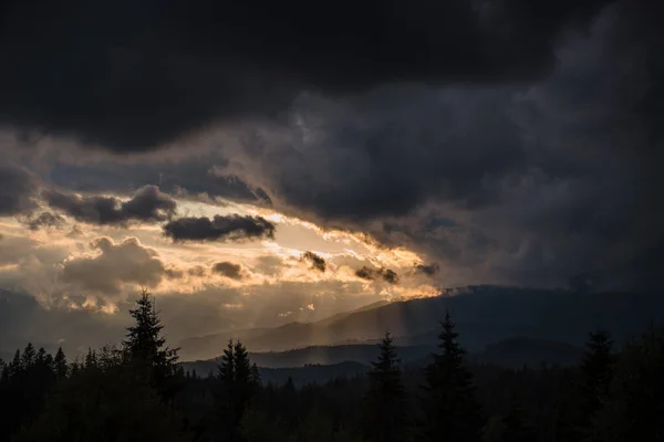 Солнечные Лучи Проходят Сквозь Темные Тяжелые Облака Над Величественными Горами — стоковое фото