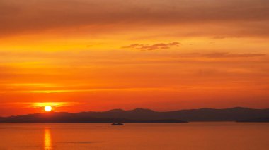 Beautiful bright sunset and boat floating in tranquil sea over mountains background. Incredible horizon with scenic seascape and colorful sky in Supetar city, Croatia. clipart