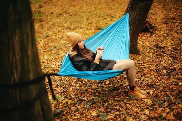 Güz Ormanlarında Mavi Hamakta Dinlenirken Bir Fincan Sıcak Çay Içen — Stok fotoğraf