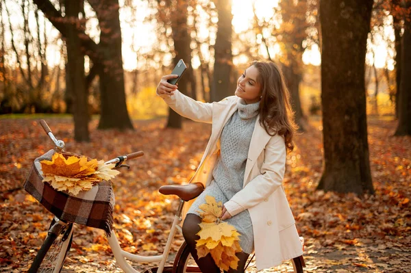 Glückliche Frau Sitzt Ihrem Fahrrad Und Macht Selfie Herbstpark Herbstmode — Stockfoto