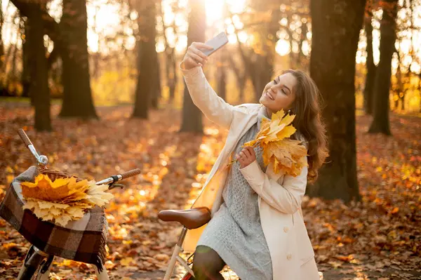 Mulher Feliz Sentada Sua Bicicleta Fazendo Selfie Parque Outono Outono — Fotografia de Stock