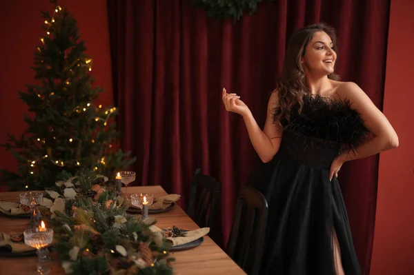 Junge Frau Schwarzem Kleid Posiert Mit Weihnachtsbaum Hause Und Lächelt — Stockfoto