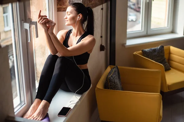 Siyah Spor Elbiseli Rahat Bir Kadın Pencerenin Yanında Otururken Müziğin — Stok fotoğraf