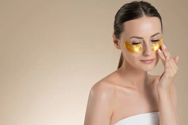Bej Arka Plan Üzerinden Gözlerinin Altına Kolajen Pedleri Kullanan Çıplak — Stok fotoğraf