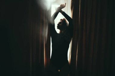 Güzel bir kadın silueti. Kolları açık pencere zemininde yükseliyor. Yaşam biçimi, kopyalama alanı.