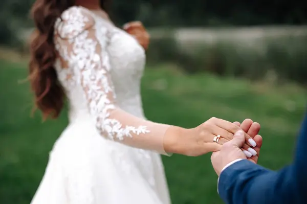 Γάμος Ζευγάρι Κρατώντας Χέρια Στο Παρασκήνιο Του Πεδίου Γαμπρός Κρατάει — Φωτογραφία Αρχείου