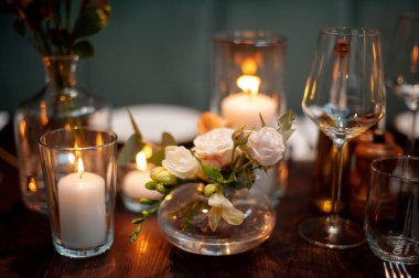 Mumları ve çiçekleri olan samimi bir düğün masası. Düğün dekoru.