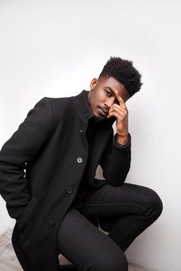 Beyaz stüdyo arka planında poz veren ve kameraya bakan sakallı çok ırklı adamın dikey portresi. 