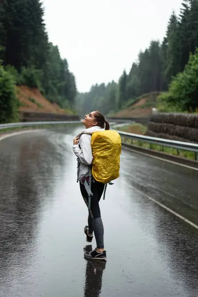Вид Сзади Женщины Туристки Желтым Рюкзаком Идущей Асфальтированной Дороге Красивыми — стоковое фото