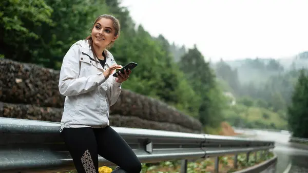 Mulher Caucasiana Jovem Verificando Direção Smartphone Moderno Enquanto Caminhando Entre Fotos De Bancos De Imagens
