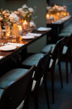 Çiçekler ve mumlarla süslü yemek masası..